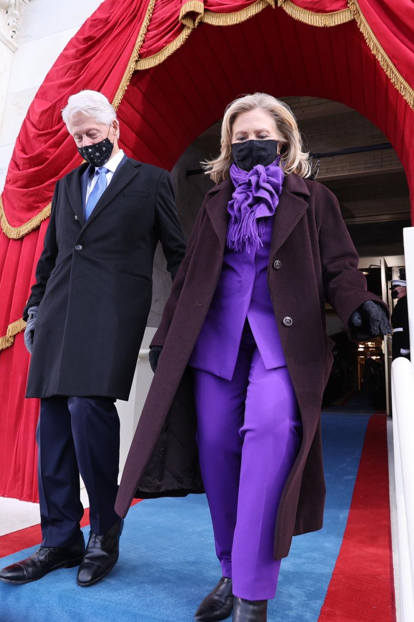 Auch Hillary Clinton wählt Lila. Über dem eleganten Hosenanzug trägt die Frau von Ex-Präsident Bill Clinton einen pflaumenfarbenen Mantel. 