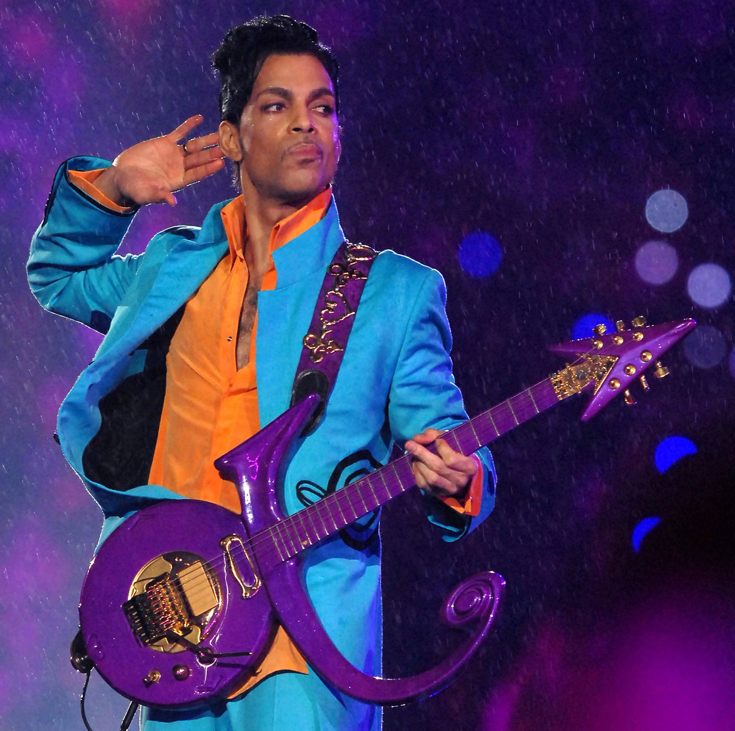 2007   Der legendäre Prince († 2016) begeistert das Super-Bowl-Publikum im Dolphins Stadion in Miami, Florida mit azurblau-orangefarbener Anzug-Kombi und seiner unverkennbaren Gitarre.