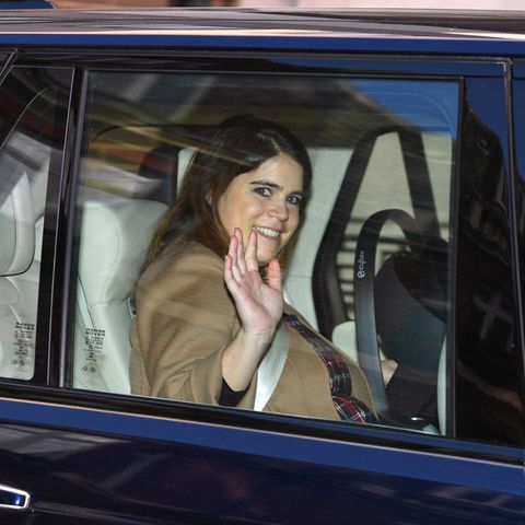Neu-Mama Prinzessin Eugenie winkt den Fotografen zu. Neben ihr auf der Rückbank sieht man eine Tragschale mit ihrem Baby. Zärtlich hat die Prinzessin ihre Hand auf ihr Kind gelegt.