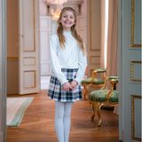 Die junge Prinzessin trägt einen kurzen Rock aus Wolle mit Schottenkaro. Er stammt vom französischen Label Bonpoint und kostet 190 Euro. Dazu kombiniert sie eine weiße Strumpfhose, eine weiße Bluse und dunkelblaue Ballerinas von Jacadi für rund 60 Euro. 