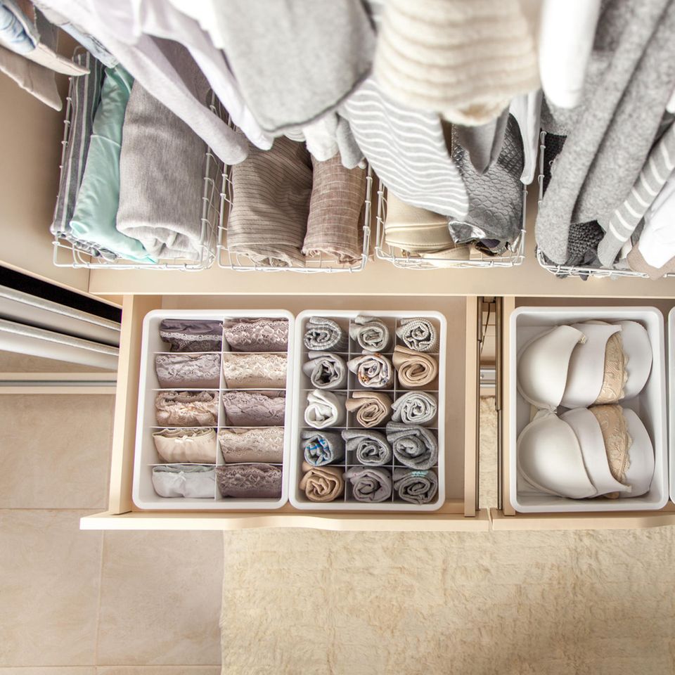 Ordnung schaffen, aufgeräumter Kleiderschrank, Frau räumt Kleiderschrank auf