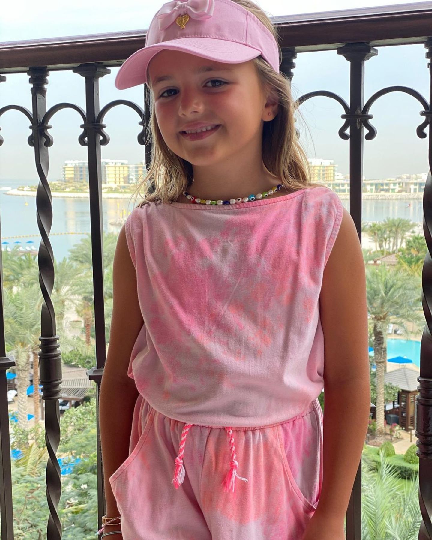 Sophia Ecclestone, die ältere Tochter von Tamara Ecclestone und Jay Rutland posiert lächelnd vor der sommerlichen Kulisse Dubais, wo die Familie gerade Urlaub macht. In einem coolen Batik-Zweiteiler, mit niedlicher Cap und Kette steht Sophia ihrer berühmten Mama modisch in nichts nach. 
