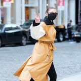 Peace! Mit stylischer Langweste in beige-gelbem Leder-Imitat ist Gigi Hadid ganz lässig in New York spazieren.