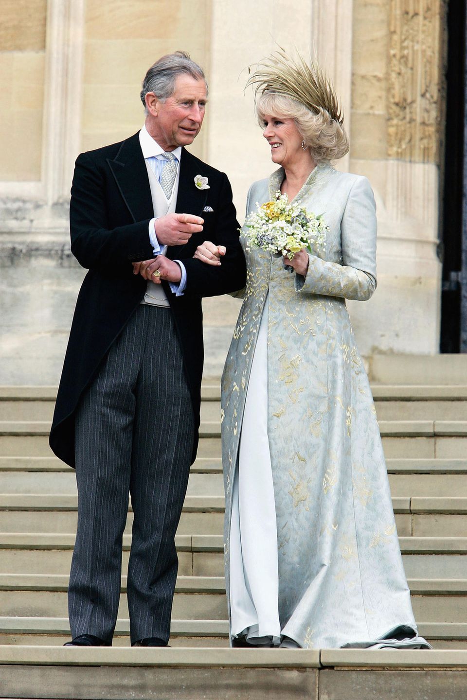 9. April 2005  Als Prinz Charles endlich seine große Liebe Camilla Parker-Bowles heiraten konnte, strahlte sie in einem beige-bläulichen Kleid aus Seidenchiffon, über dem sie einen aufwändig bestickten Seidenmantel trug. Besonderer Hingucker war aber das federnbesetzte Hütchen von Philip Treacy.