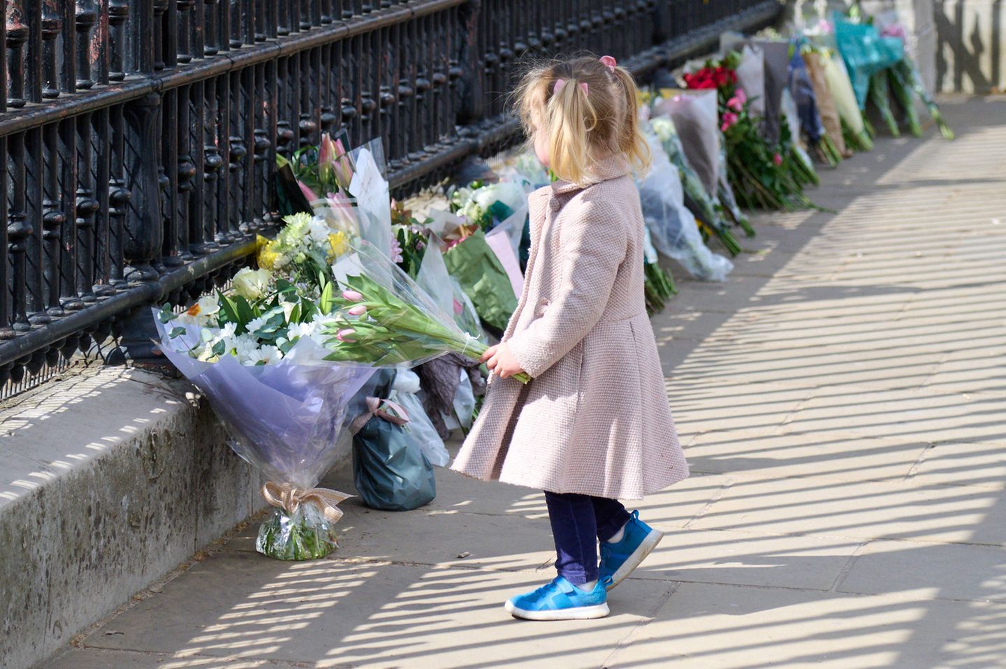 Tausende Menschen legen Blumen vor den Palasttoren in London nieder und kondolieren der royalen Familie – so auch dieses kleine Mädchen.
