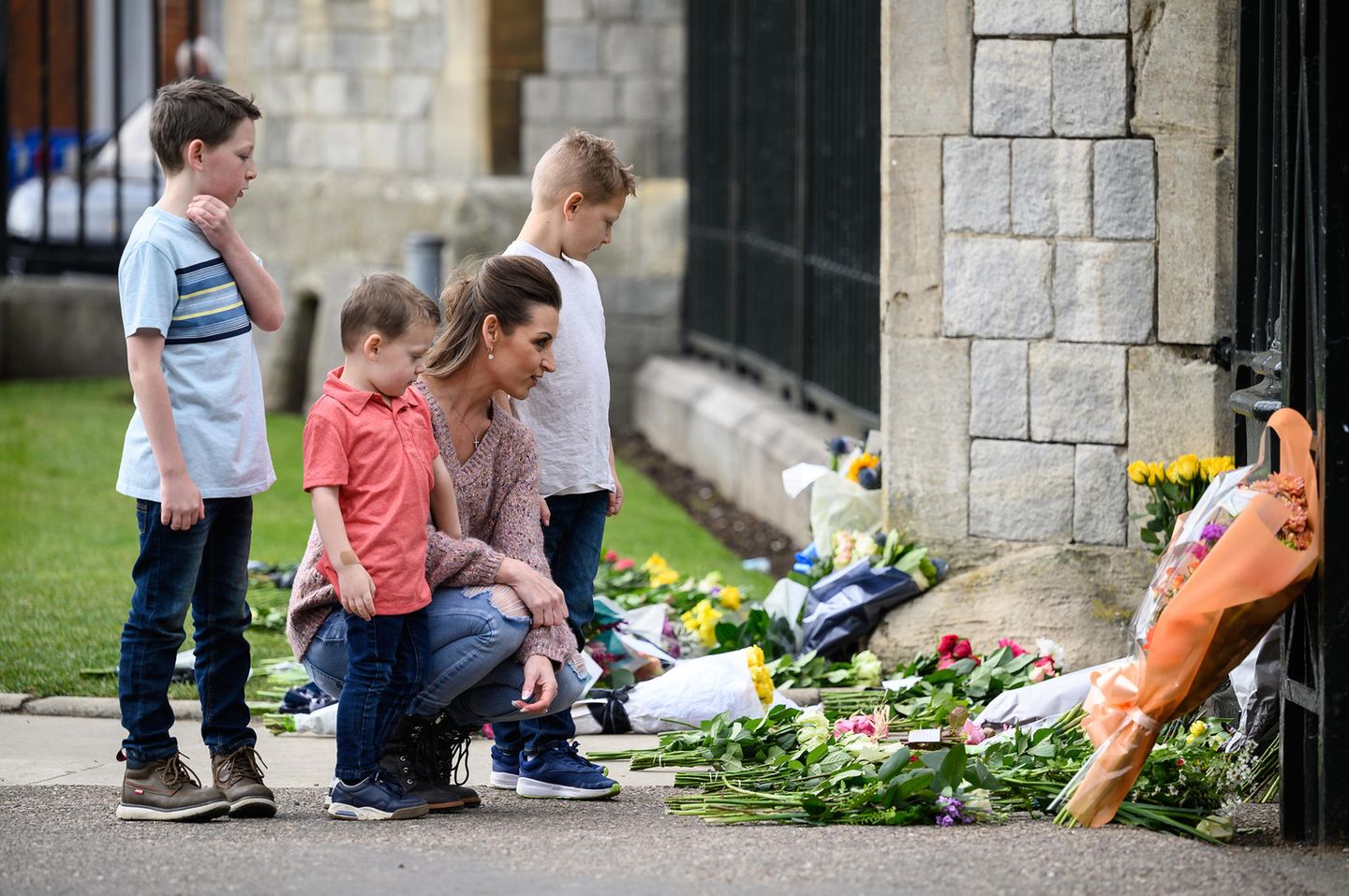 Das Blumenmeer vor dem Buckingham Palast wächst stündlich weiter. In solch schweren Momenten rückt die Familie zusammen. Auch dieses Quartett kondoliert der Königin gemeinsam zu ihrem Verlust.
