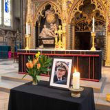 Nach dem Tod von Prinz Philip wird zu seinen Ehren ein kleiner Altar in der Westminster Abbey errichtet. Neben einem gerahmten Porträtfoto vom Herzog von Edinburgh leuchtet eine weiße Kerze. Auch ein bunter Strauß Blumen mit jeder Menge Grün ist auf dem schwarz dekorierten Tisch zu finden.