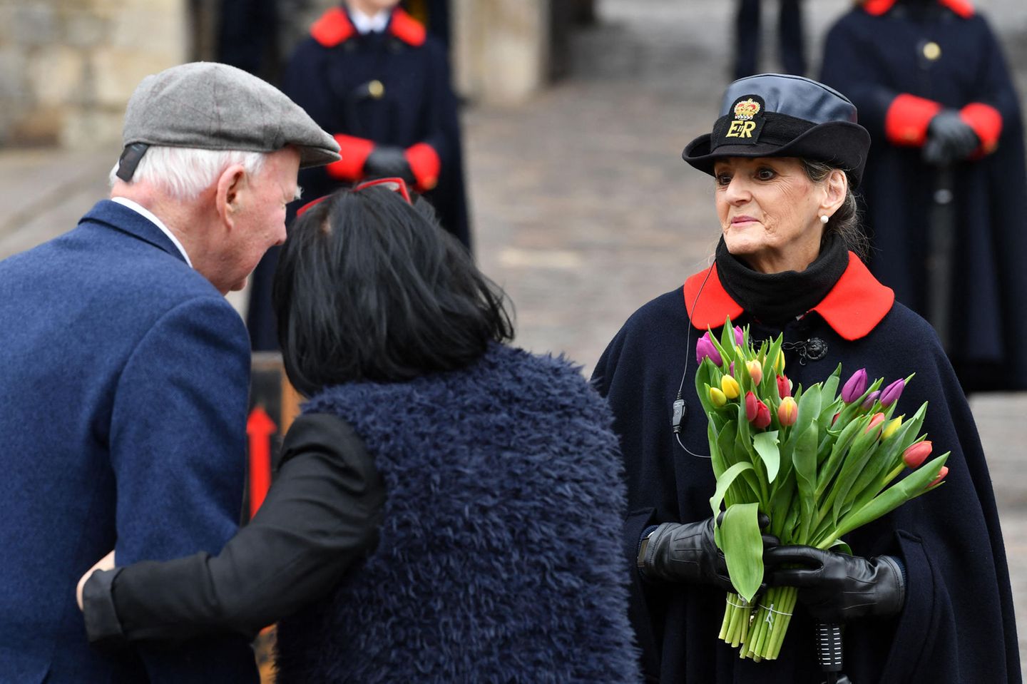 Blumen in Gedenken an den verstorbenen Prinz Philip: Ein Paar überreicht einer Aufseherin vor den Toren von Schloss Windsor einen bunten Strauß Tulpen. Warme Worte bauen während des großen Verlusts auf.