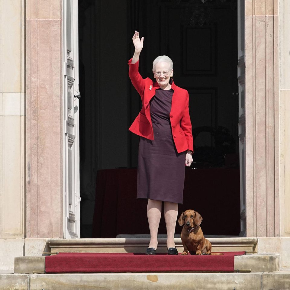 Zum 81. Geburtstag zeigt sich Königin Margrethe in Fredensborg mit einem großen Lächeln auf den Lippen. Dabei trägt das dänische Königsoberhaupt ein Etuikleid in der Farbe Lila und kombiniert dazu eine rote Blazerjacke. Besonders niedlich: Auch Dackeldame Tillia darf mit auf die Schlosstreppe zum Geburtstagswinken. 