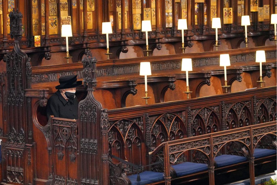 Queen Elizabeth: Die Queen hat in der Kapelle Platz genommen. Gleich werden sich weitere Familienmitglieder in ihre Sitzreihe gesellen – allerdings mit weitem Abstand. Queen Elizabeth sitzt in der St George’s Chapel alleine.