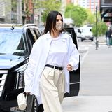 Mit weitem, weißen Hemd und beigefarbener Bundfaltenhose schickt Kendall Jenner einen modischen Gruß an die Achtziger.