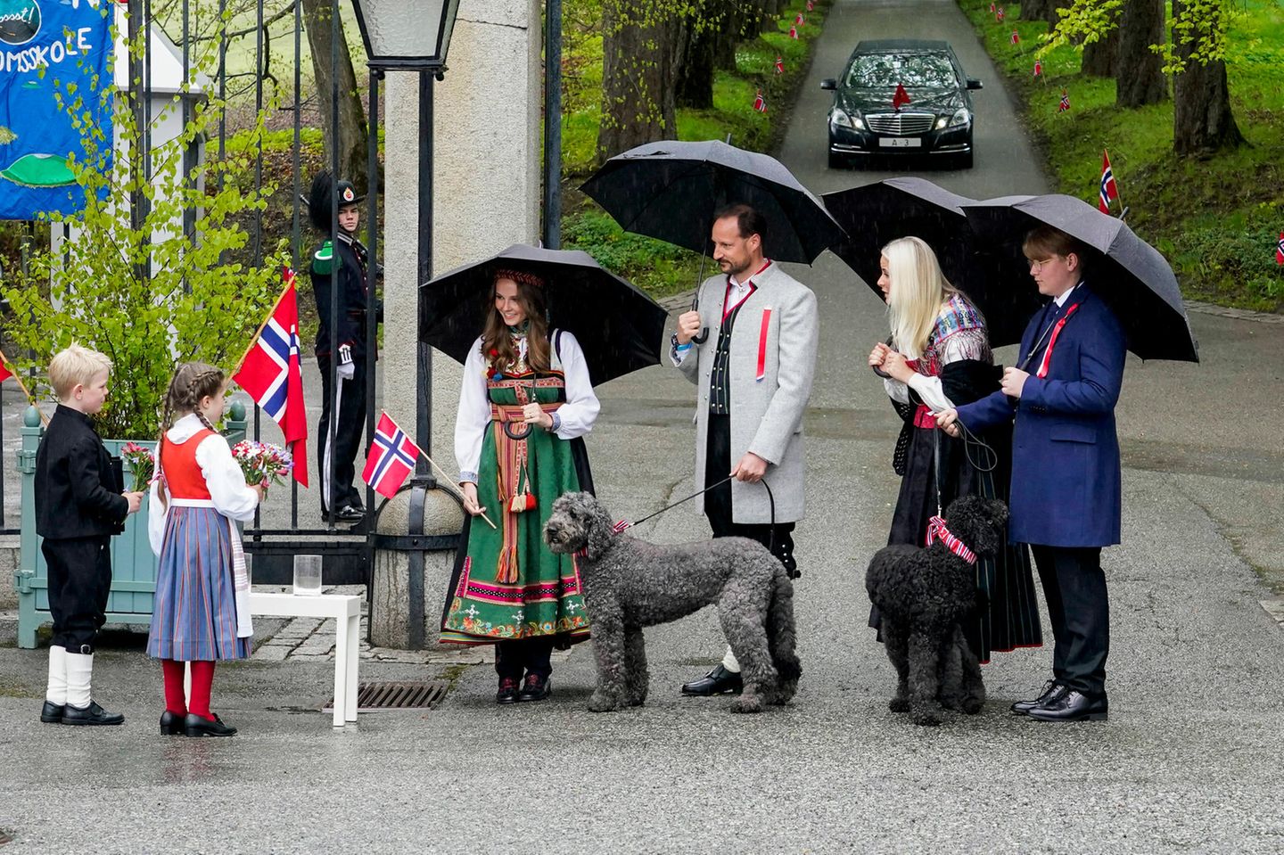 17. Mai 2021   Prinz Haakon und Prinzessin Mette-Marit werden zusammen mit Prinzessin Ingrid Alexandra und Prinz Sverre Magnus herzlich von zwei Kindern mit Blumensträußen auf Gut Skaugum in Asker bei Oslo empfangen. Die Familienhunde Milly Kakao und Muffin dürfen ebenfalls an den Feierlichkeiten zum norwegischen Nationalfeiertag teilnehmen. 