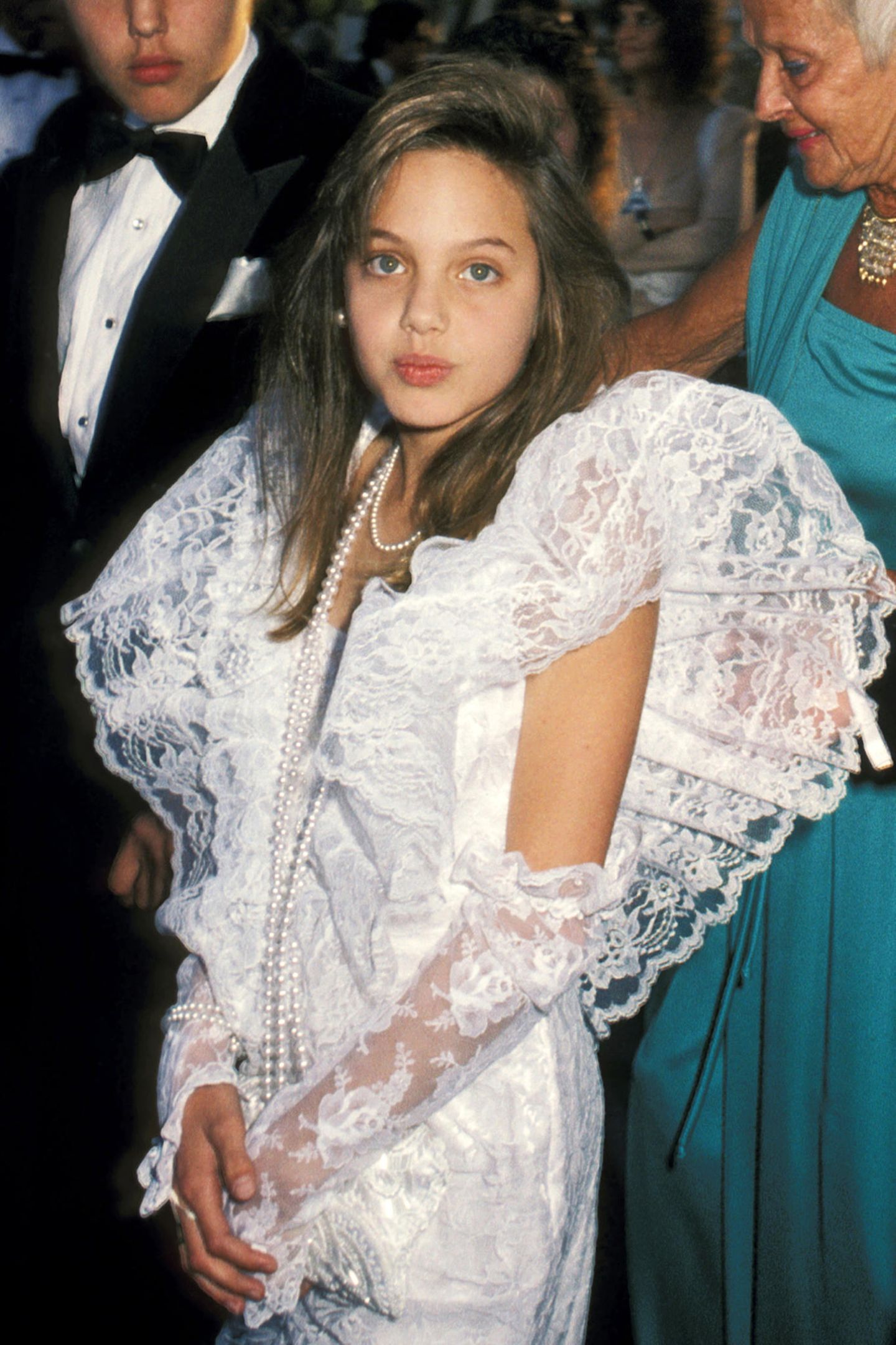 1986 Als Tochter des Schauspielerpaars Jon Voight und Marcheline Bertrand wächst Angelina Jolie mit dem Glamour und Trubel Hollywoods auf. Als niedliche Zehnjährige gibt sie sogar schon ihr Debüt auf dem roten Teppich der Oscars, ganz unschuldig im weißen Spitzenkleid.