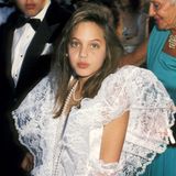 1986  Als Tochter des Schauspielerpaars Jon Voight und Marcheline Bertrand wächst Angelina Jolie mit dem Glamour und Trubel Hollywoods auf. Als niedliche Zehnjährige gibt sie sogar schon ihr Debüt auf dem roten Teppich der Oscars, ganz unschuldig im weißen Spitzenkleid.
