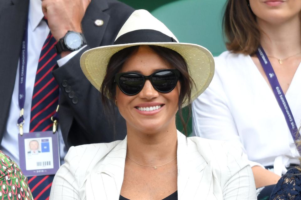 Herzogin Meghan mit Sonnenbrille und Panama-Hut. 