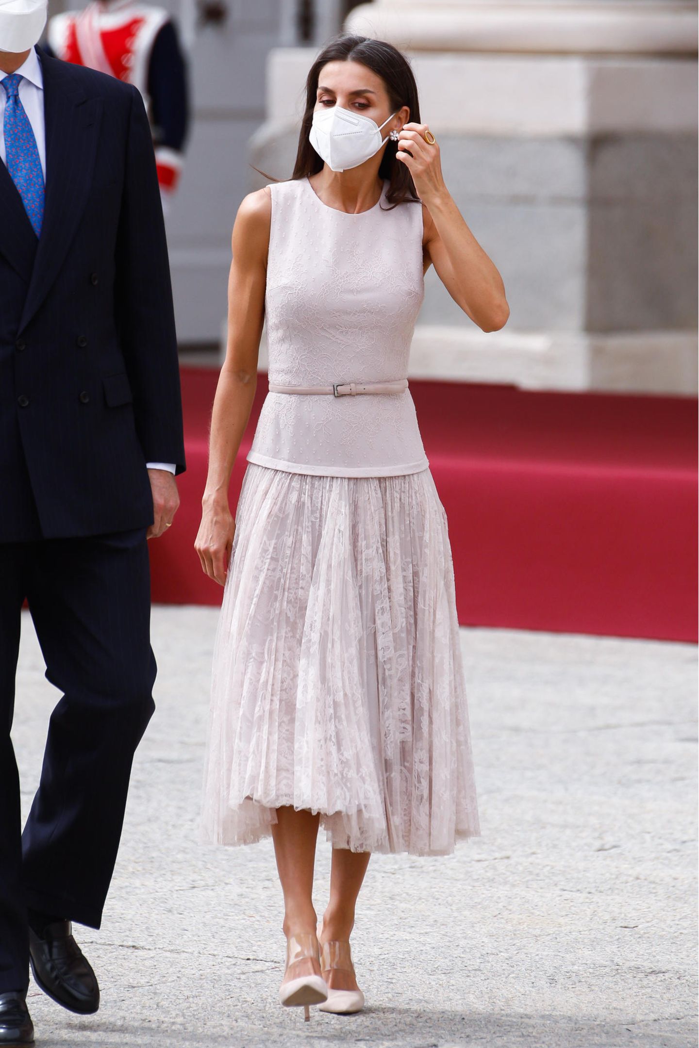 Königin Letizia zeigt sich bei der Begrüßung des Staatsbesuches aus Korea in einem edlen Look in zartem Rosa. Für den ersten Auftritt des Tages entscheidet sie sich für ein Kleid mit Spitzenrock von Varela, das sie mit Pumps von Steve Madden und Ohrringen von Joyeria Yanes kombiniert.