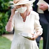 Herzogin Camilla lässt sich nicht lange bitten und besucht gemeinsam mit Ehemann Prinz Charles auch am zweiten Tag das Pferderennen in Ascot. Dafür setzt sie auf ein zartgelbes Kleid von Fiona Clare Couture mit passendem Mund-Nasen-Schutz sowie einen farblich perfekt darauf abgestimmten Hut von Philip Treacy. 