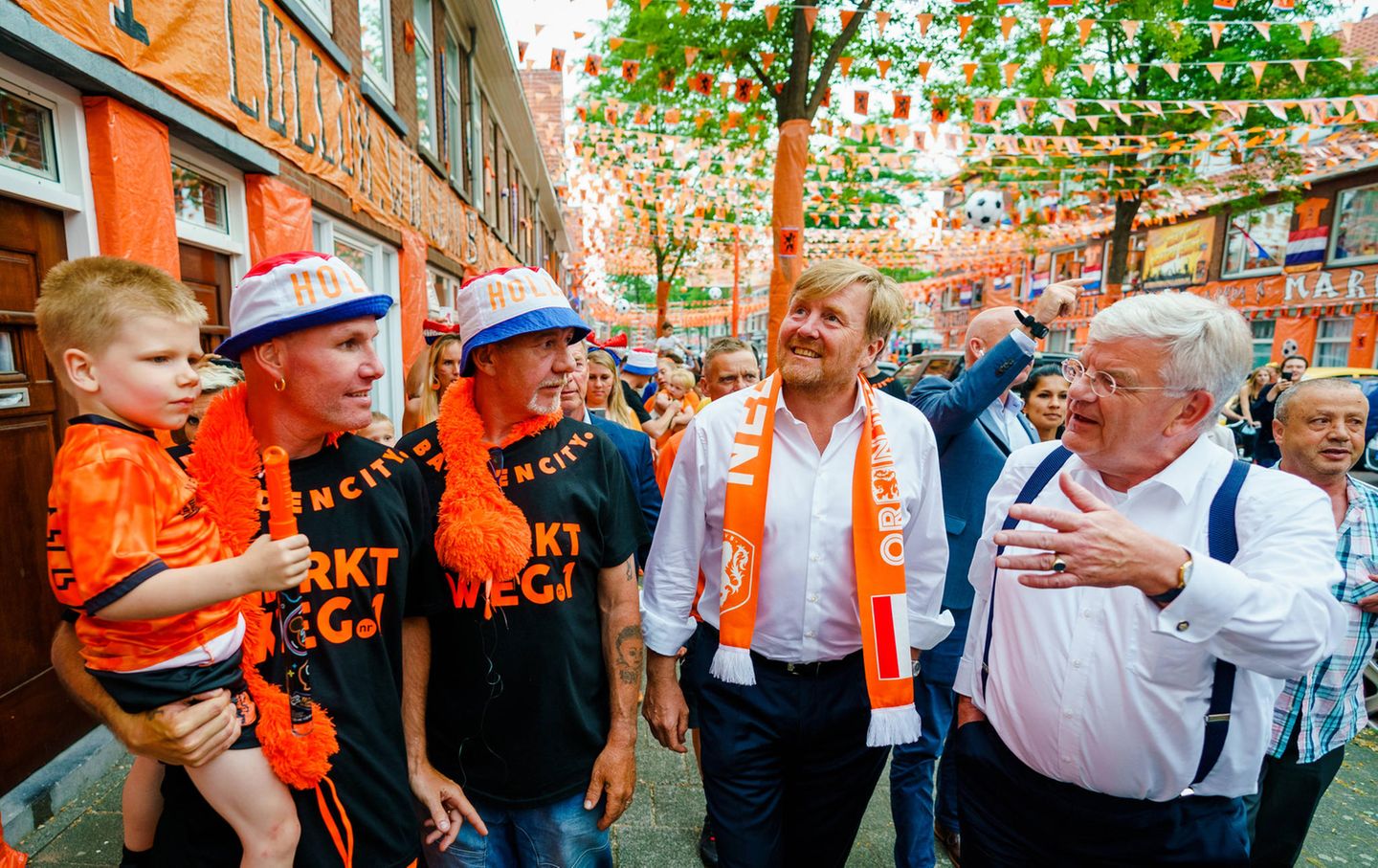 17. Juni 2021  In ein orangefarbenes Meer aus Flaggen, Schals und Hüten taucht König Willem-Alexander kurz vor dem Beginn des Fußball-EM-Spiels Niederlande gegen Österreich ein. Auf dem Marktplatz in Den Haag bewundert er die aufwendig dekorierte Fanmeile und trägt selbst einen Fan-Schal um den Hals.
