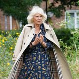 Bei der Eröffnung einer Bücherei an einer Grundschule in Cornwall macht Herzogin Camilla, wie immer, eine gute Figur. Besonders harmonisch: Die Farben des gemusterten Kleides wiederholen sich im Futter des Burberry-Trenchcoats, einem echten Lieblingsteil von Modeprofis.