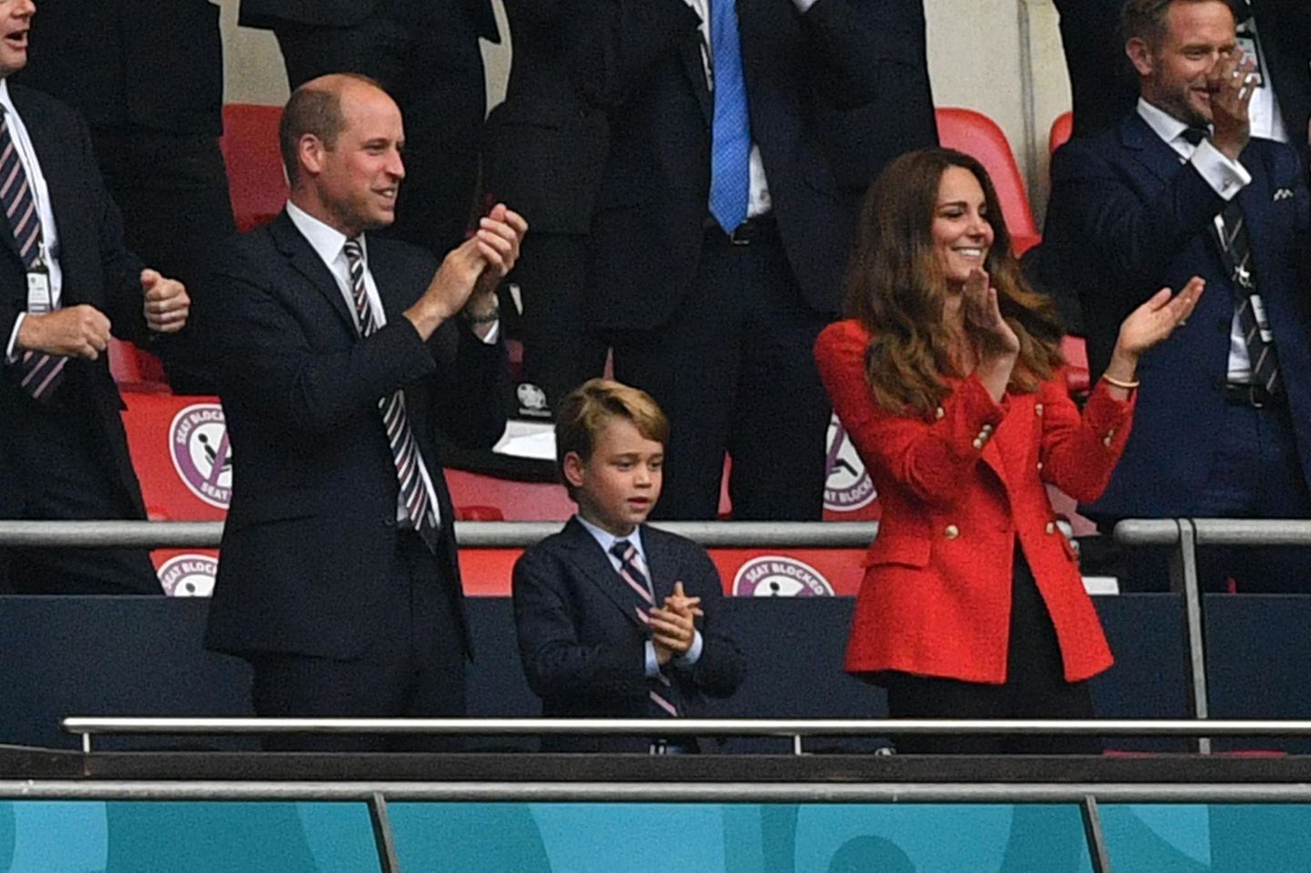 Im schicken Anzug mit Hemd und Krawatte zeigen sich Prinz William und Prinz George zu diesem Anlass im eleganten Partnerlook. Herzogin Catherine strahlt in Rot von der Tribüne im Wembley-Stadion.