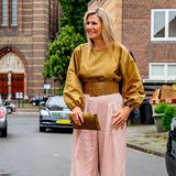 Königin Maxima in einer gelben Bluse und rosa Hose