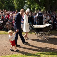 5. Juli 2015  Bei schönstem Sommerwetter schreitet Familie Cambridge an vielen Fans und Zuschauern vorbei Richtung St. Mary Magdalene Church in Sandringham. Und alle Augen sind nicht nur auf Prinzessin Charlotte im Kinderwagen gerichtet, sondern auf ihren quirligen Bruder Prinz George.