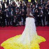 Zur "Stillwater"-Premiere in Cannes präsentiert Jodie Turner-Smith bereits einen zweiten Hingucker-Look im Rahmen der Filmfestspiele: Die Schauspielerin setzt auf eine Robe mit Corsagen-Oberteil, die an einen mit Federn besetzen Rock  mit Schleppe knüpft. 