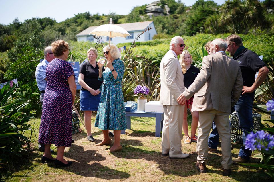 In Bryher angekommen, informieren sich Herzogin Camilla und Prinz Charles bei den Betreibern der Hillside Farm über deren Hof. Die britischen Royals werden mit kühlen Getränken im idyllischen Garten der Farm empfangen. In Bryher angekommen, informieren sich Herzogin Camilla und Prinz Charles bei den Betreibern der Hillside Farm über deren Hof. Die britischen Royals werden mit kühlen Getränken im idyllischen Garten der Farm empfangen.