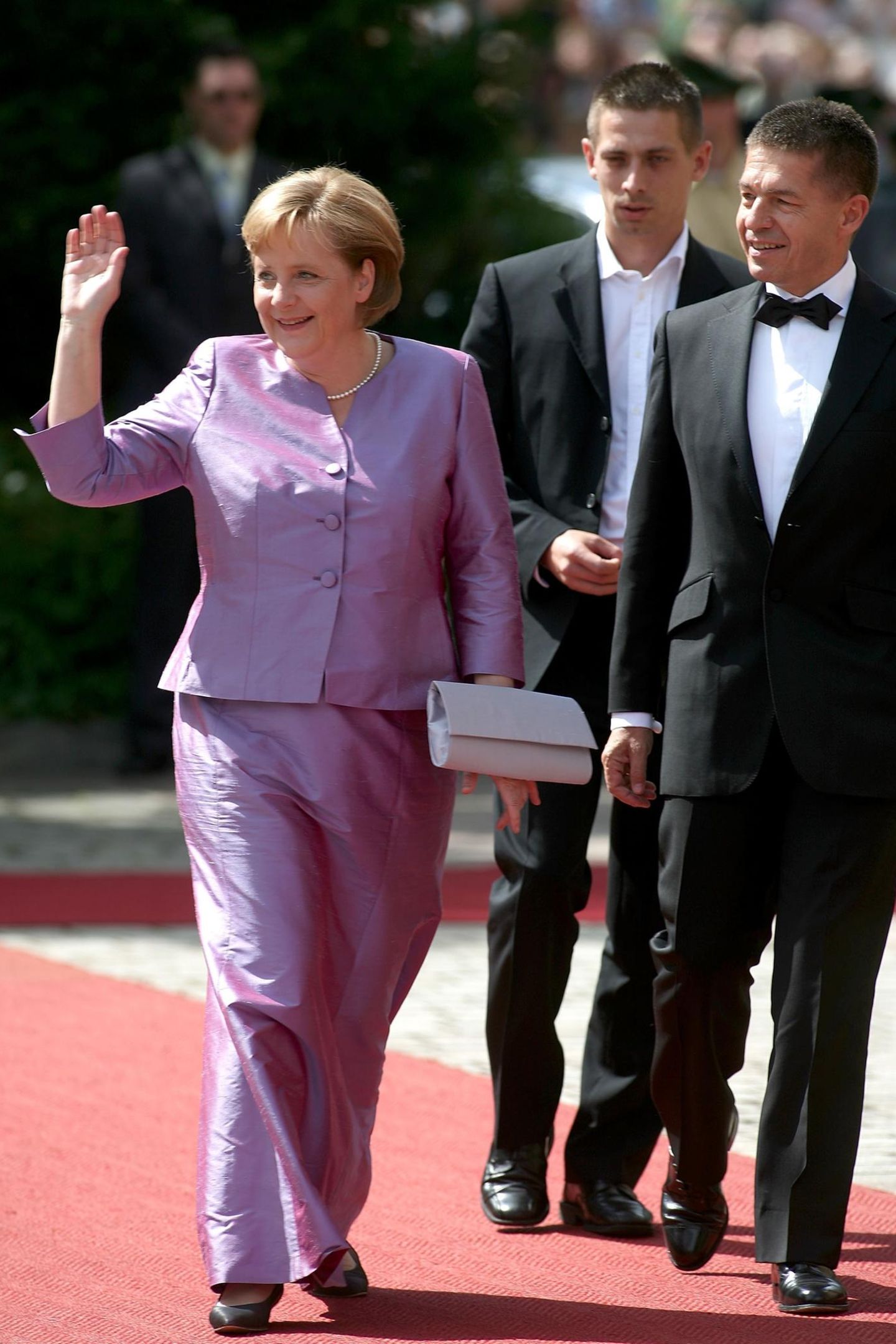 Angela Merkel winkt den Menschen am Red Carpet zu.