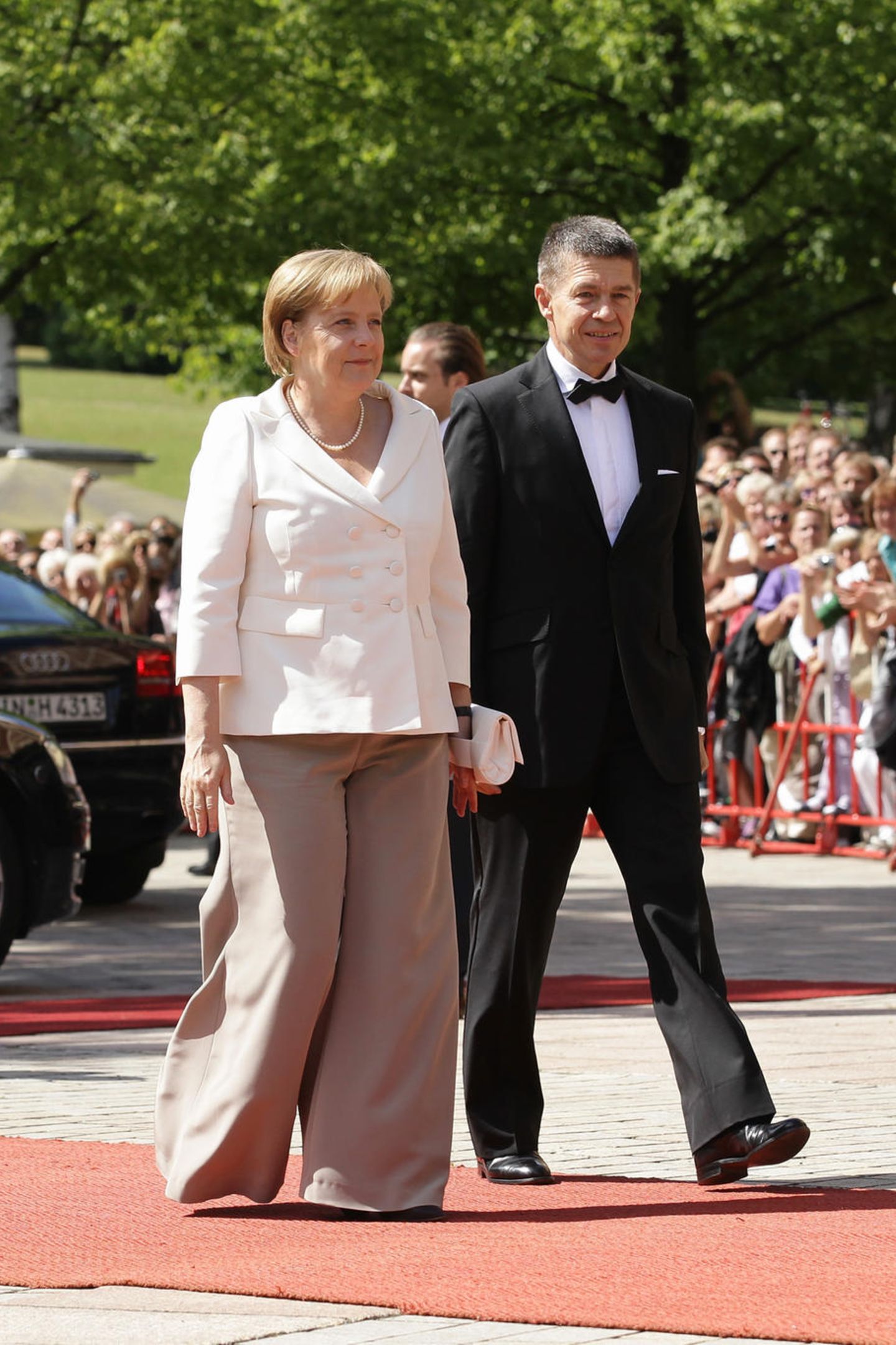 Angela Merkel und Joachim Sauer laufen auf dem Red Carpet in Bayreuth.