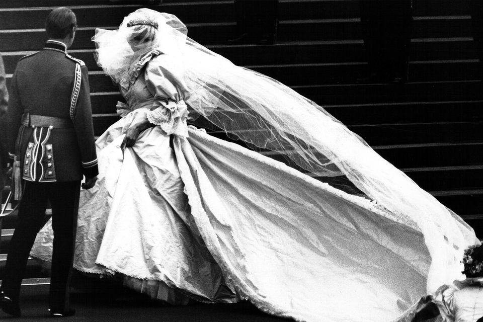 Lady Dianas Schleppe ist die längste in der Geschichte der Monarchie. Ihr Seidentüllschleier war mit winzigen Perlmutt-Pailletten von Hand bestickt. Die Designerin, Elizabeth Emanuel, wollte, dass es wie Feenstaub aussah. Lady Dianas Schleppe ist die längste in der Geschichte der Monarchie. Ihr Seidentüllschleier war mit winzigen Perlmutt-Pailletten von Hand bestickt. Die Designerin, Elizabeth Emanuel, wollte, dass es wie Feenstaub aussah.