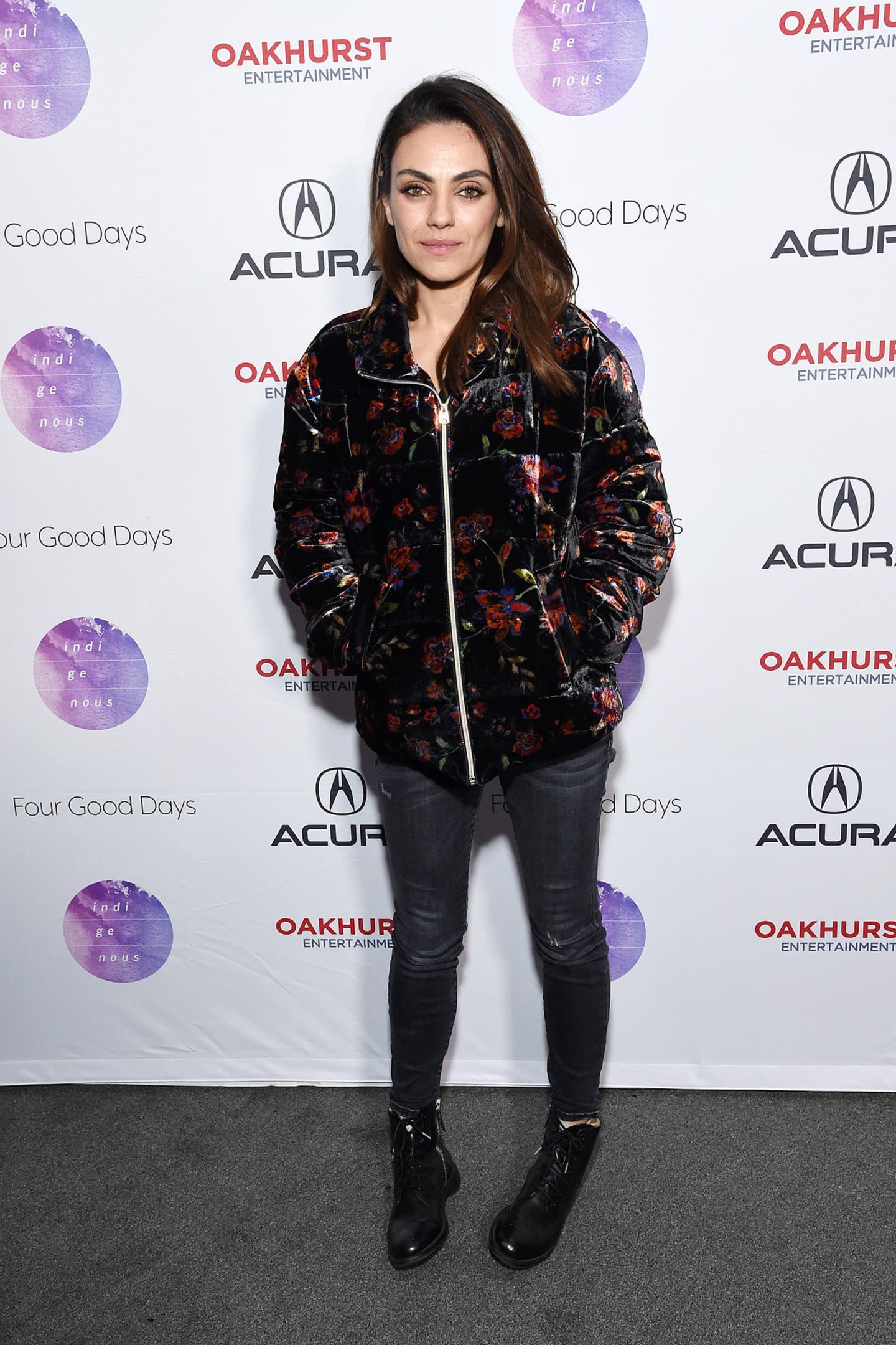 Heute lässt es Mila Kunis etwas lässiger auf dem Roten Teppich angehen: Mit dunkler Jeans, Samt-Blouson und Boots stellt sie sich vor die Fotograf:innen. 