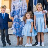 Auch Nicolas von Schweden reiht sich in den Dresscode mit ein, trägt ebenfalls eine dunkelblaue Anzugsjacke. Allerdings in Kombination mit einer langen Anzugshose in Grau und einer hellblauen Krawatte. Seine Schwestern Adrienne und Leonore erscheinen im Partnerlook. Ihre Kleider stammen von dem Label Trotters und bestechen durch ein blaues Blumenmuster, einen weißen Bubi-Kragen und kleinen Puffärmeln. Das Kleid gibt es jeweils für 118 Euro. 