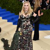 Unauffällig ist dieses Outfit von Madonna auf der Metropolitan Museum of Art Gala im Jahr 2017 nicht. Und das obwohl die Sängerin auf ein Slipdress mit Camouflagemuster und Lederhandschuhen sowie einer Tarndecke in ihrer Hand setzt. Mag wohl daran liegen, dass Madonna nicht im Wald, sondern auf einem Red-Carpet steht. 