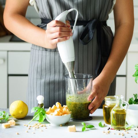 Stabmixer-Test: Diese Modelle können überzeugen, Frau bereitet grünes Pesto zu