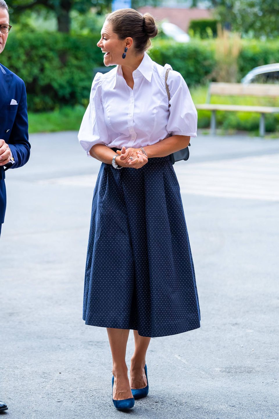 Prinzessin Victoria ist das perfekte Beispiel dafür, wie lässige Eleganz funktioniert. Zum dunkelblauen Midirock mit süßem Pünktchen-Muster kombiniert sie eine weiße Bluse mit Puffärmeln. Dunkelblaue Wildleder-Heels verleihen dem Outfit die nötige Eleganz. Doch der besondere Eyecatcher findet sich an der Schulter der Kronprinzessin baumelnd. Prinzessin Victoria ist das perfekte Beispiel dafür, wie lässige Eleganz funktioniert. Zum dunkelblauen Midirock mit süßem Pünktchen-Muster kombiniert sie eine weiße Bluse mit Puffärmeln. Dunkelblaue Wildleder-Heels verleihen dem Outfit die nötige Eleganz. Doch der besondere Eyecatcher findet sich an der Schulter der Kronprinzessin baumelnd.