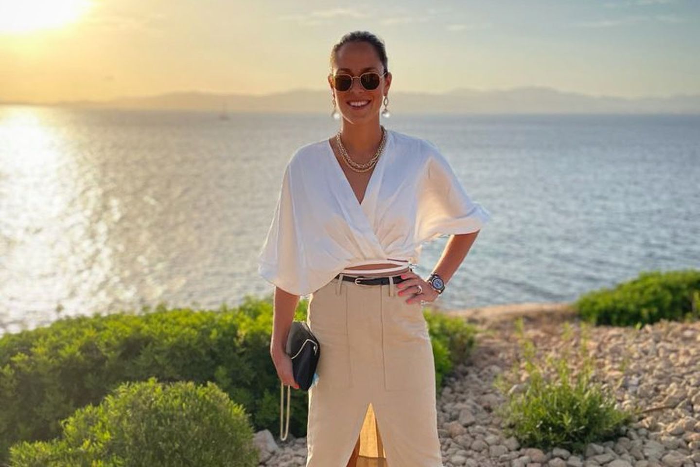 Vor einem wunderschönen Sonnenuntergang zeigt sich Ana Ivanovic wie gewohnt elegant in einer weißen Bluse und einem knielangen Bleistift-Rock mit Beinschlitz.
