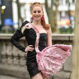 ''Riverdale''-Star Madeleine Petsch zeigt sich vor der Moschino-Show in einem extravaganten Kleid des gleichnamigen Designers. Die Besonderheit des Looks: Das schwarze Minidress wird durch einen rosa Glitzer-Flamingo verziert.