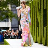 Moschino feiert in diesem Jahr sein Debüt auf der New York Fashion Week. Zu diesem besonderen Anlass trägt Model Gigi Hadid auf dem Laufsteg der Show ein langes One-Shoulder-Dress mit ausgefallener Schulterpartie. Der Hingucker des Outfits: In der rechten Hand hält die schöne Blondine eine Babyflasche, an der sie mit lässigem Blick Richtung Publikum nuckelt. 