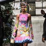 Die skurrilen Accessoires ziehen sich durch die Fashion-Show von Moschino: Das Model Taylor Hill trägt eine Kopfbedeckung, die an einen Spielbogen für Babys erinnert. 