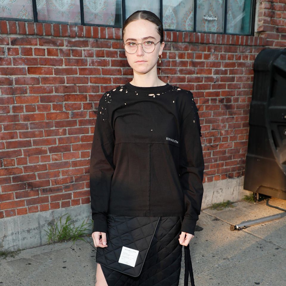 Ella Emhoff inspiriert nicht nur durch ihren Charakter, sondern auch durch ihren Mode-Stil. Ihr Styling wirkt unglaublich durchdacht und dabei unverschämt lässig. So auch bei der Fashion-Show von Eckhaus Latta. Hier setzt die 22-Jährige auf einen Wickel-Stepprock und Pullover in Schwarz.