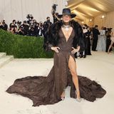 Howdy! Jennifer Lopez setzt auf ein Kleid mit Beinschlitz und XL-Ausschnitt von Ralph Lauren. Dazu kombiniert sie Hut, Felljacke und auffälligen Schmuck.