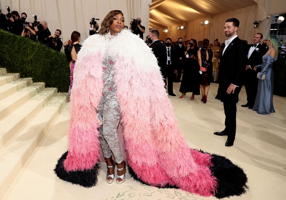 Drama pur! Tennisstar Serena Williams erscheint in silbernen Overall mit Federmantel von Gucci. Drama pur! Tennisstar Serena Williams erscheint in silbernen Overall mit Federmantel von Gucci.