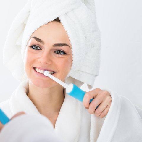 Deals des Tages: Frau beim Zähneputzen mit elektrischer Zahnbürste, Zahnreinigung
