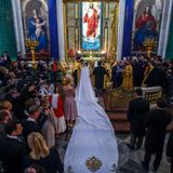 Rebecca Bettarini entscheidet sich für ein schlichtes weißes Brautkleid samt Schleier und meterlanger Schleppe. Den Kopf der Braut schmückt außerdem ein diamantenbesetztes Diadem.