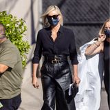 Charlize Theron beweist in hochbündigem Leder-Look zur schwarzen Bluse, dass sie genau weiß, wie lässiger Streetstyle funktioniert.