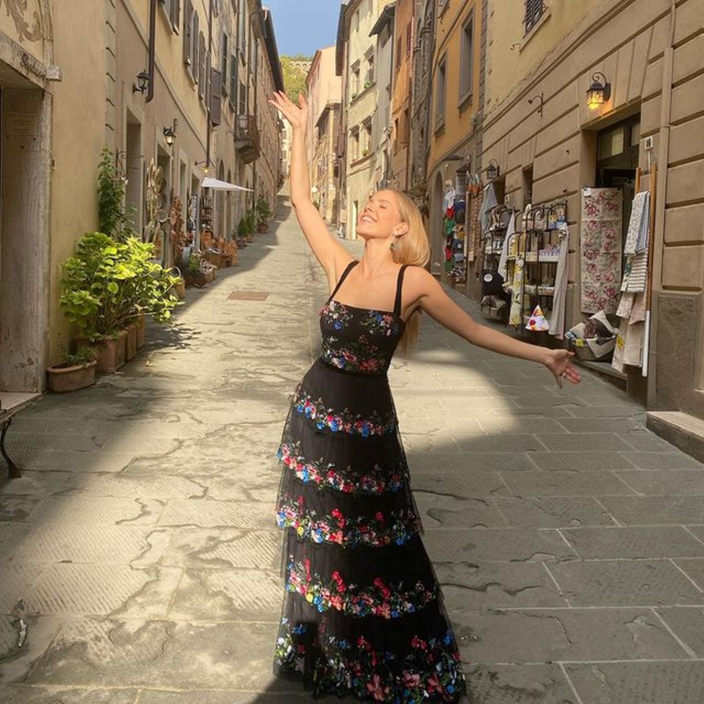Für eine Hochzeit in Italien wirft sich Moderatorin Victoria Swarovski in dieses super elegante Outfit. Das bodenlange Kleid mit Blumendetails und verschiedenen Lagen aus Tüll passt perfekt nach Italien.