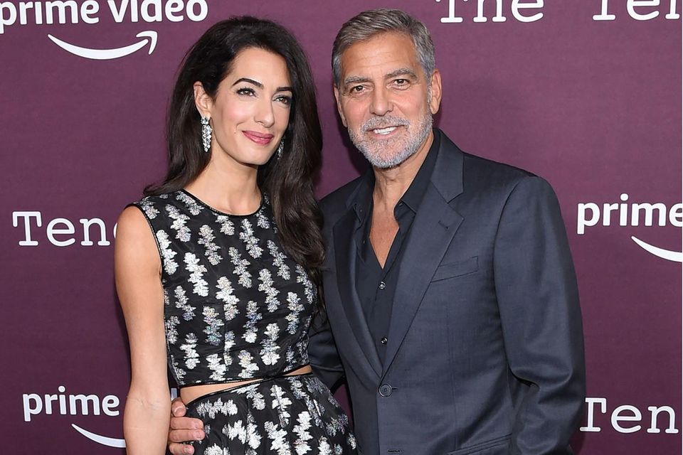 Amal Clooney und George Clooney posieren auf dem Red Carpet für die Fotografen.