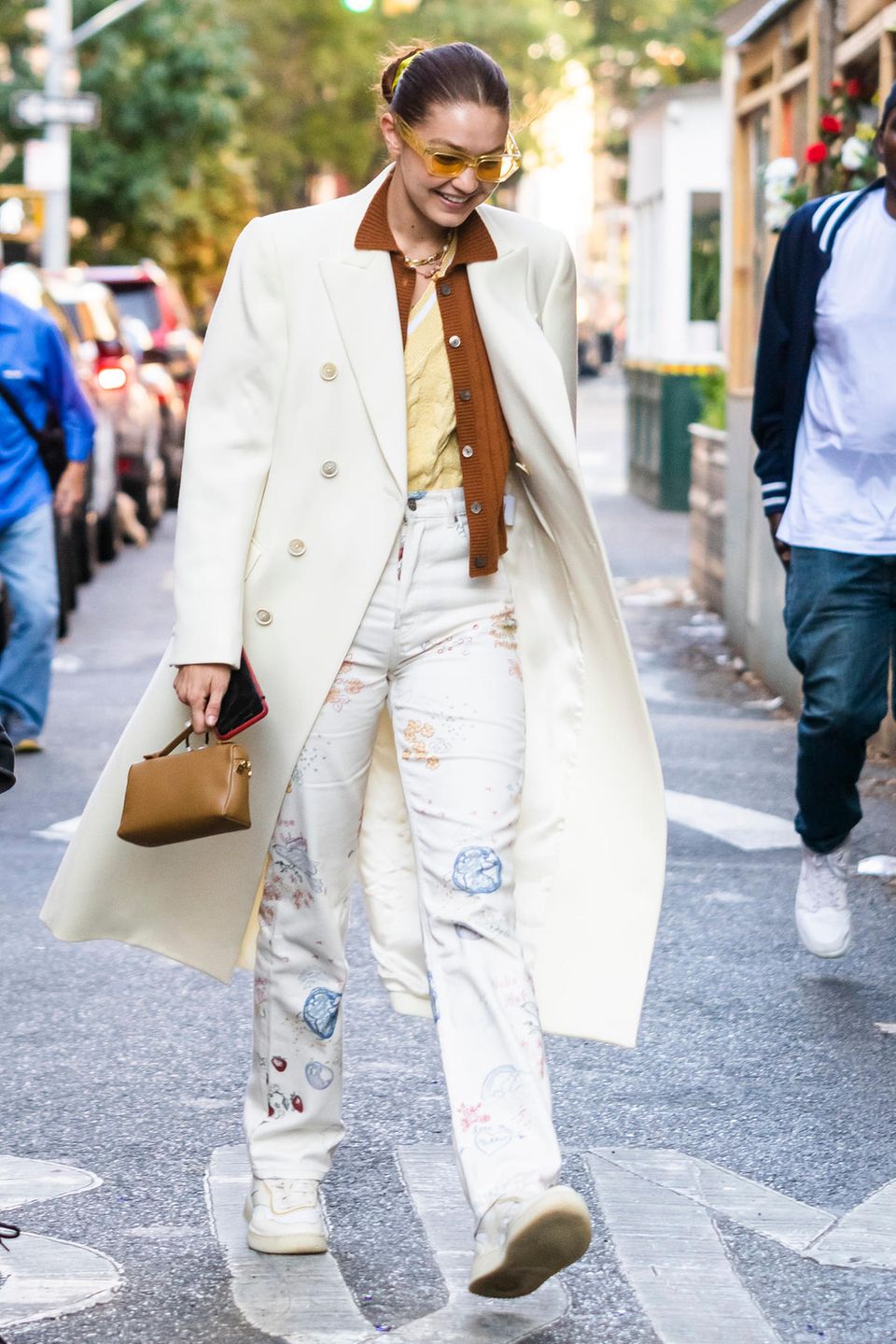 Gigi Hadid, auffällig wie immer! In einem creme-weißen Mantel huscht die Modelmama durch New York City. Sie kombiniert den zweireihigen Mantel mit gedeckten Farben, wobei Gigis Sonnenbrille den aus den 70ern inspirierten Look vervollständigt.