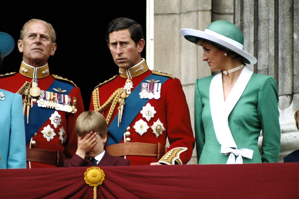 Prinz Philip, Prinz Charles und Prinzessin Diana mit Prinz William, der sich die Hand vors Gesicht schlägt, auf dem Balkon des Buckingham Palasts anlässlich der "Trooping the Color"-Zeremonie am 11. Juni 1988